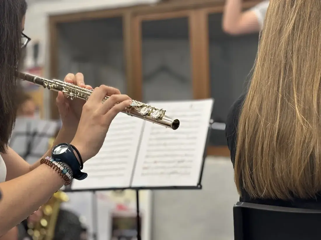 Una flautista de la Banda Reino de León toca junto a su partitura